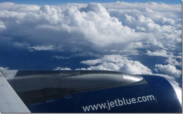 a jet blue plane wing and clouds
