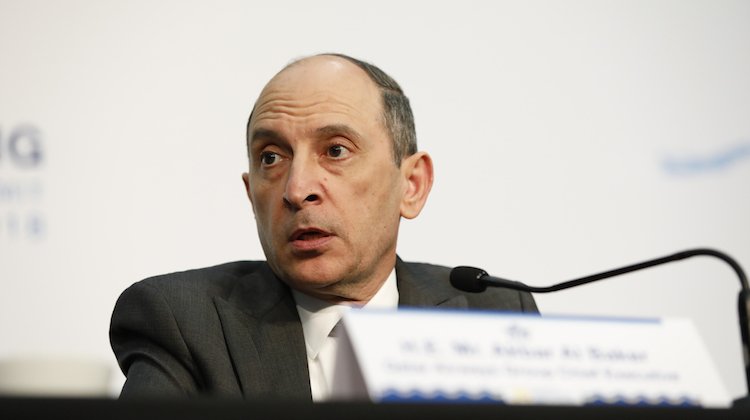 a man in a suit speaking into a microphone