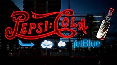 a neon sign with a sign pointing to the left