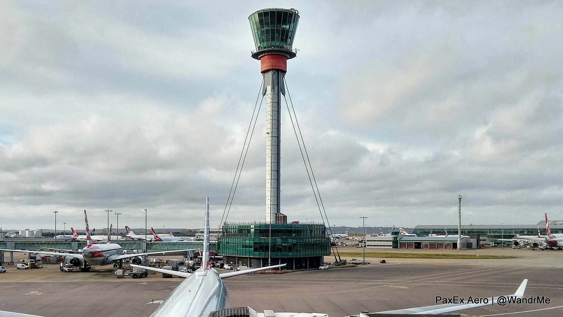 a tower with a glass tower and a plane in the background