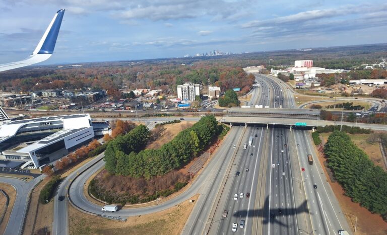 Shadow of a plane crossing over a highway, as seen from inside the plane